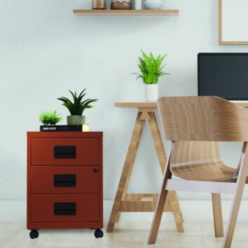 Caisson mobile à tiroirs Soho terracotta avec trois tiroirs, placé dans un bureau moderne avec plantes.