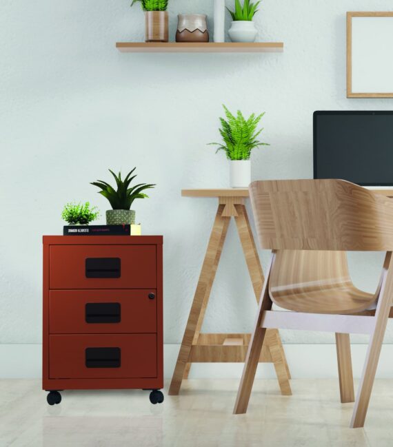 Caisson mobile à tiroirs Soho terracotta avec trois tiroirs, placé dans un bureau moderne avec plantes.