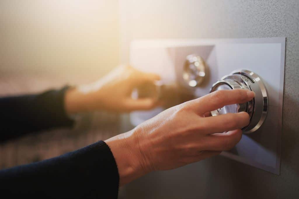 Fermeture de la porte d'un coffre fort par une main de femme