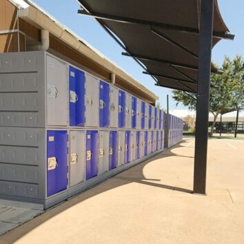 Casier Polyéthylène TOPP à 2 compartiments, hauteur 181 cm, installés en extérieur près d'un terrain de sport.