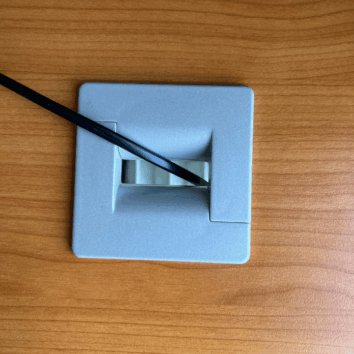 Obturateur carré aluminium sur bureau ligne PLUSet, surface en bois clair.